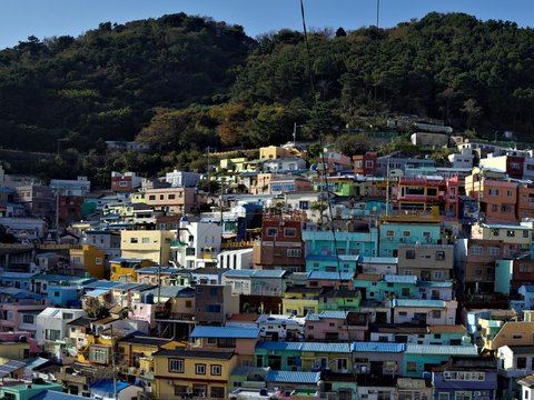 Colorful houses on a hillside under a mountain.