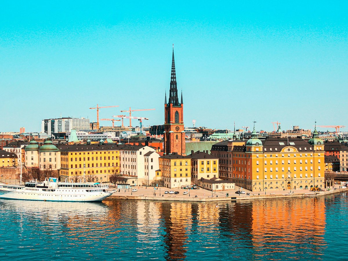 white boat on water near city buildings during daytime