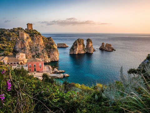 photo of house near cliff and body of water