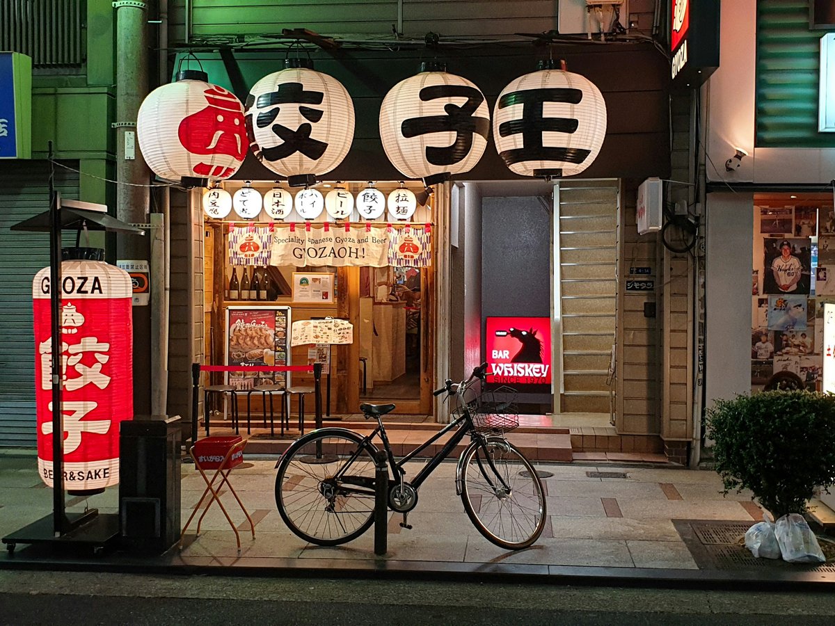red and black bicycle parked beside store during daytime