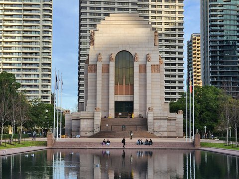 A monument in the middle of a lake surrounded by tall buildings
