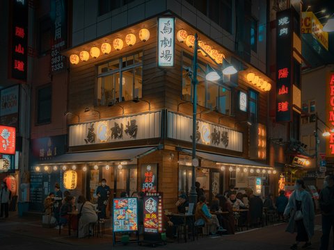 a group of people standing outside of a restaurant at night