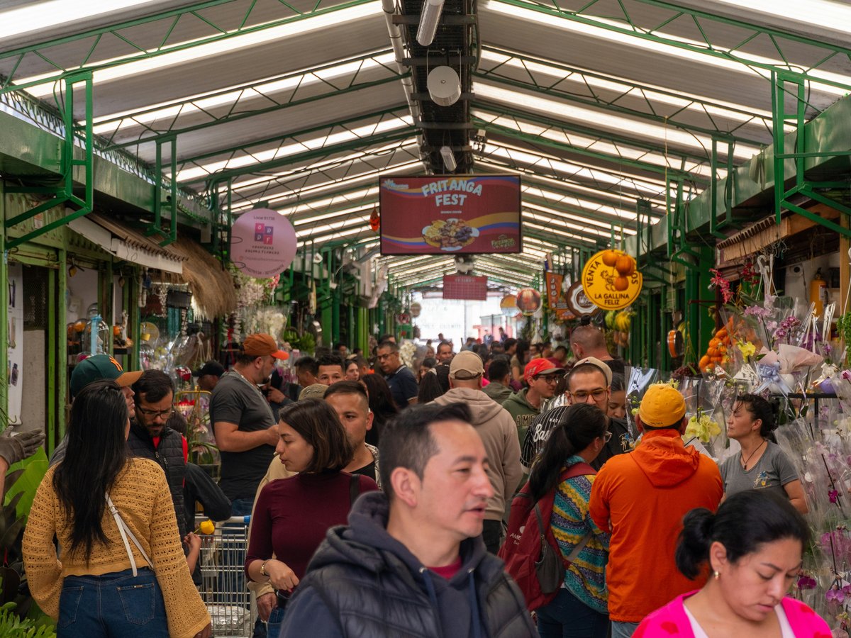 Crowded indoor market with stalls and shoppers