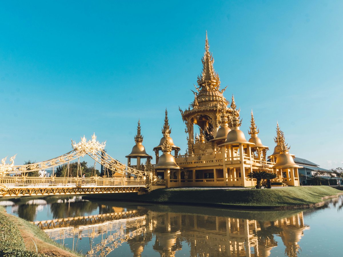 a large golden building sitting on top of a lake