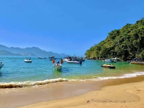 a beach with boats and people
