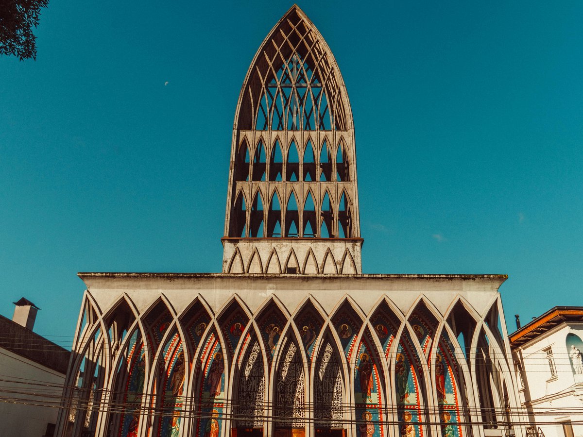 a church with a tall steeple and stained glass windows