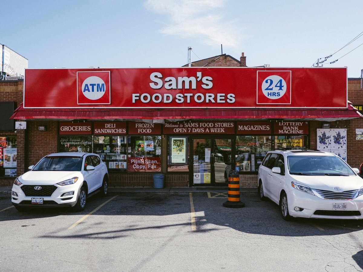 A sam's food store with cars parked in front of it