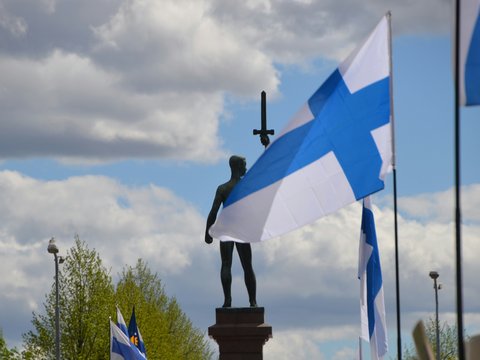a statue of a person holding a cross and a flag