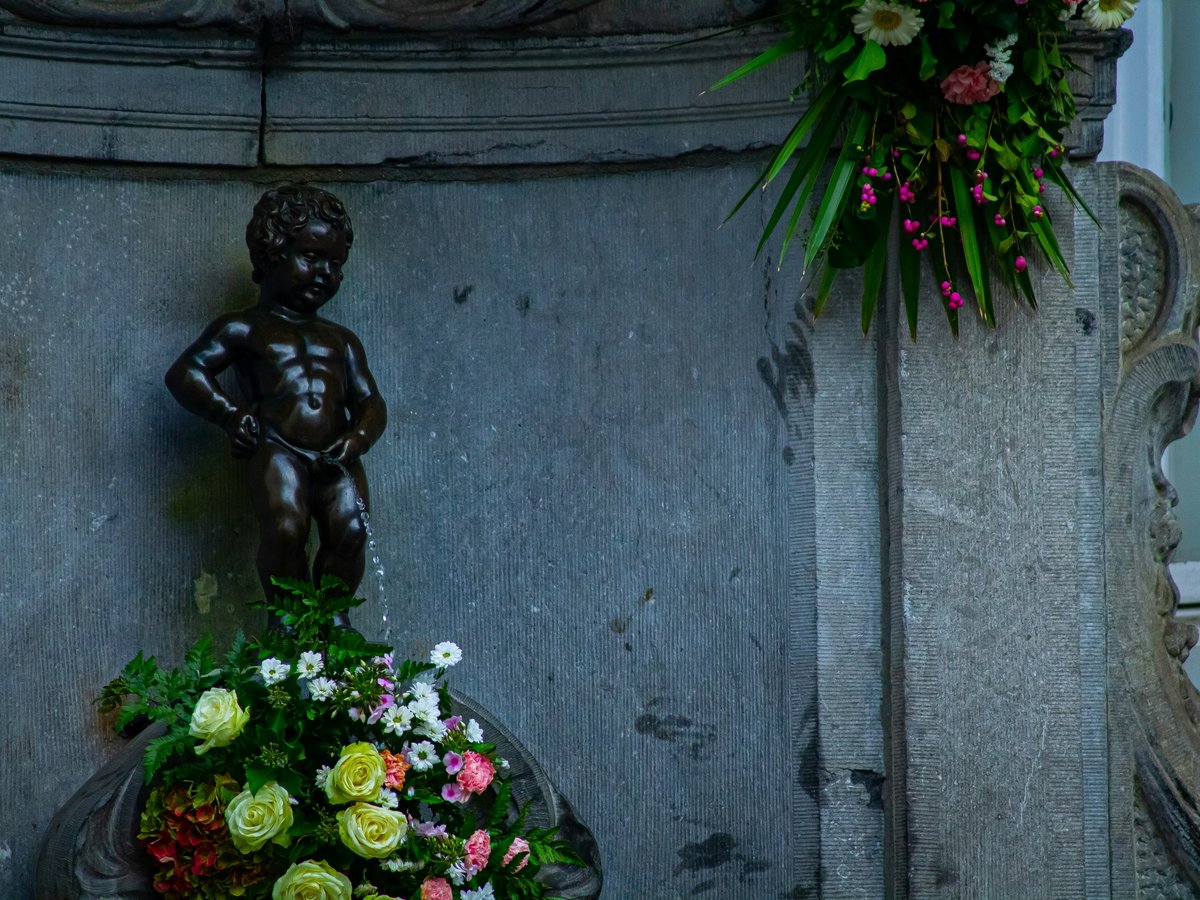 a statue of a boy holding a bouquet of flowers