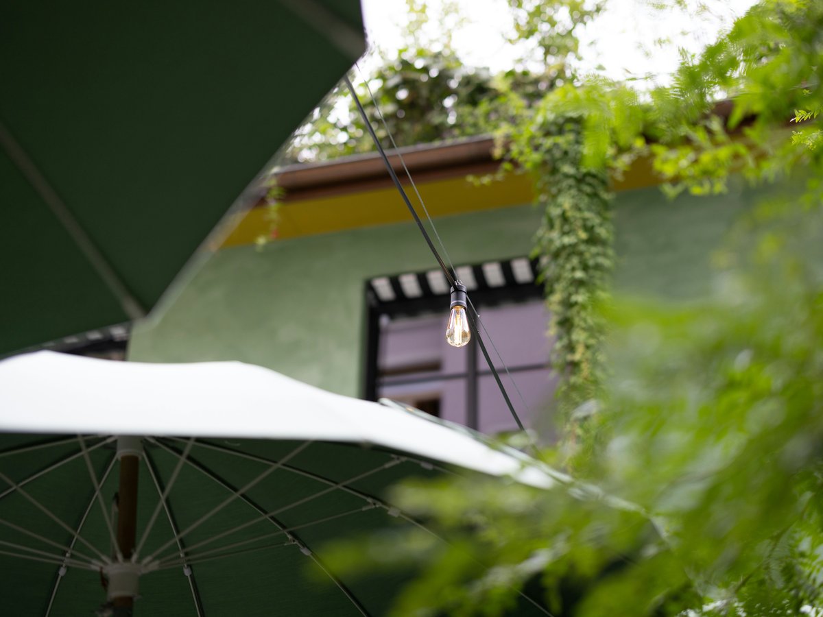 An open umbrella sitting in front of a green building