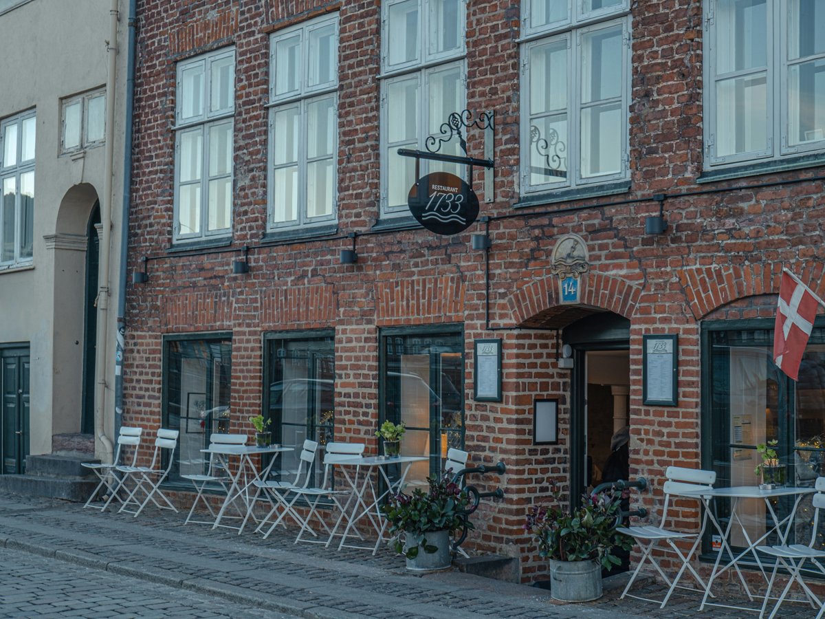 a brick building with tables and chairs outside