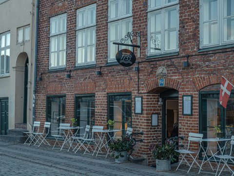 a brick building with tables and chairs outside