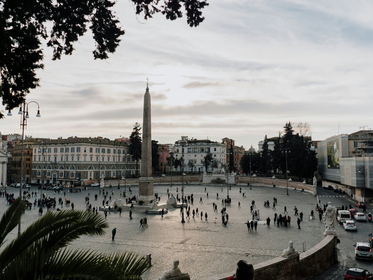 a group of people walking around a city square