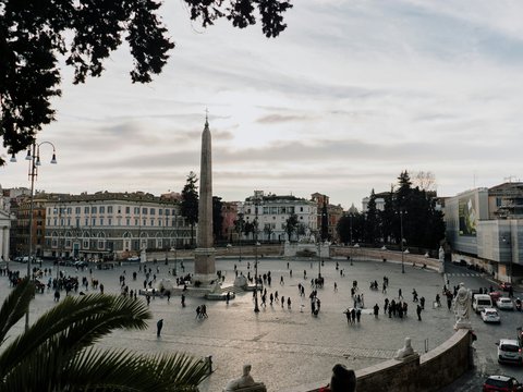 a group of people walking around a city square