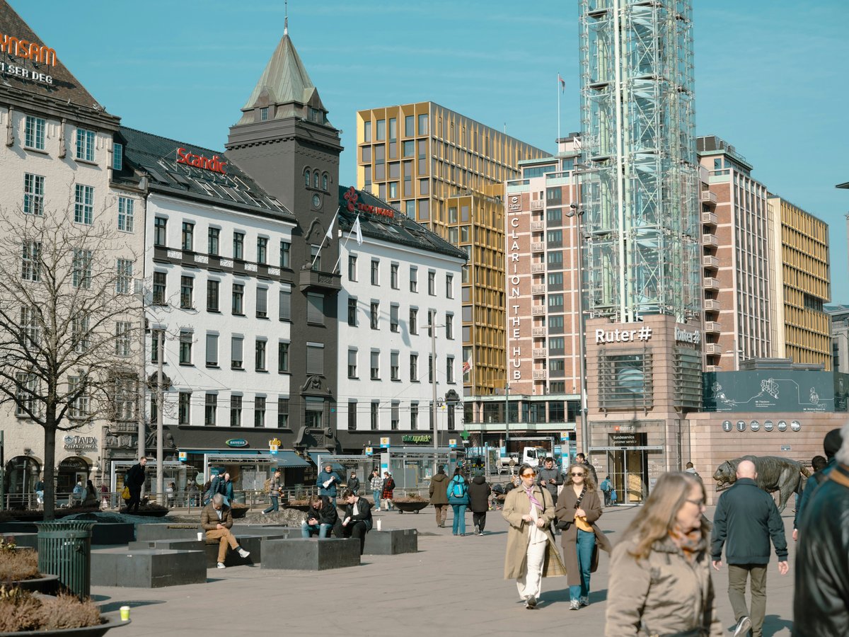 a group of people walking around a city square