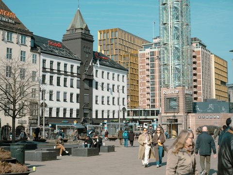 a group of people walking around a city square