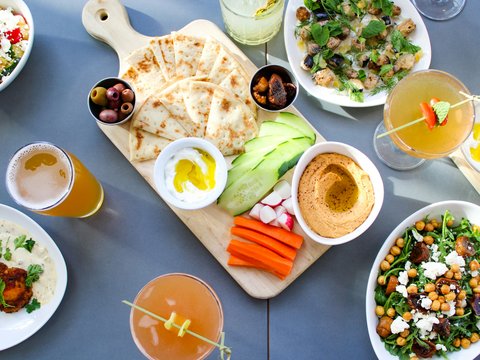 A table topped with plates of food and drinks