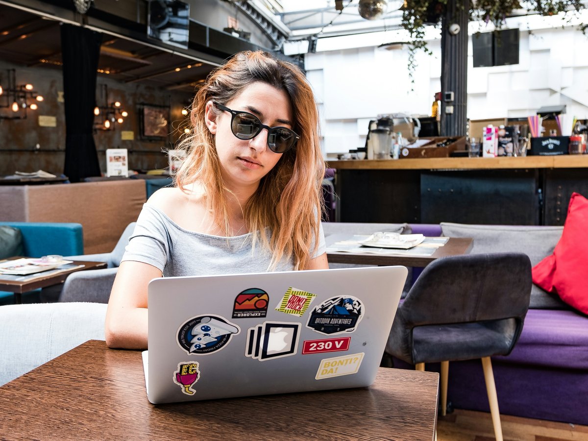 a woman sitting at a table with a laptop