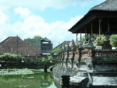 a pond in front of a building with a clock tower in the background