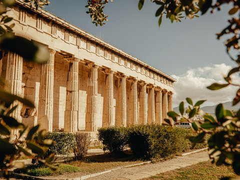 a large building with columns and a lot of trees