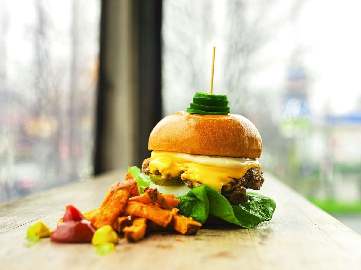 burger with lettuce and tomato on white ceramic plate