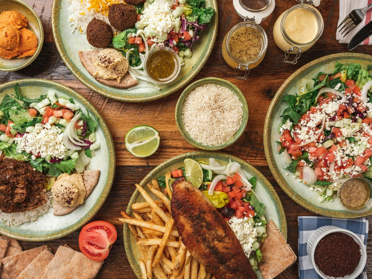 A wooden table topped with plates of food