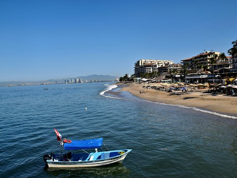 Beach scene with boats and resort buildings