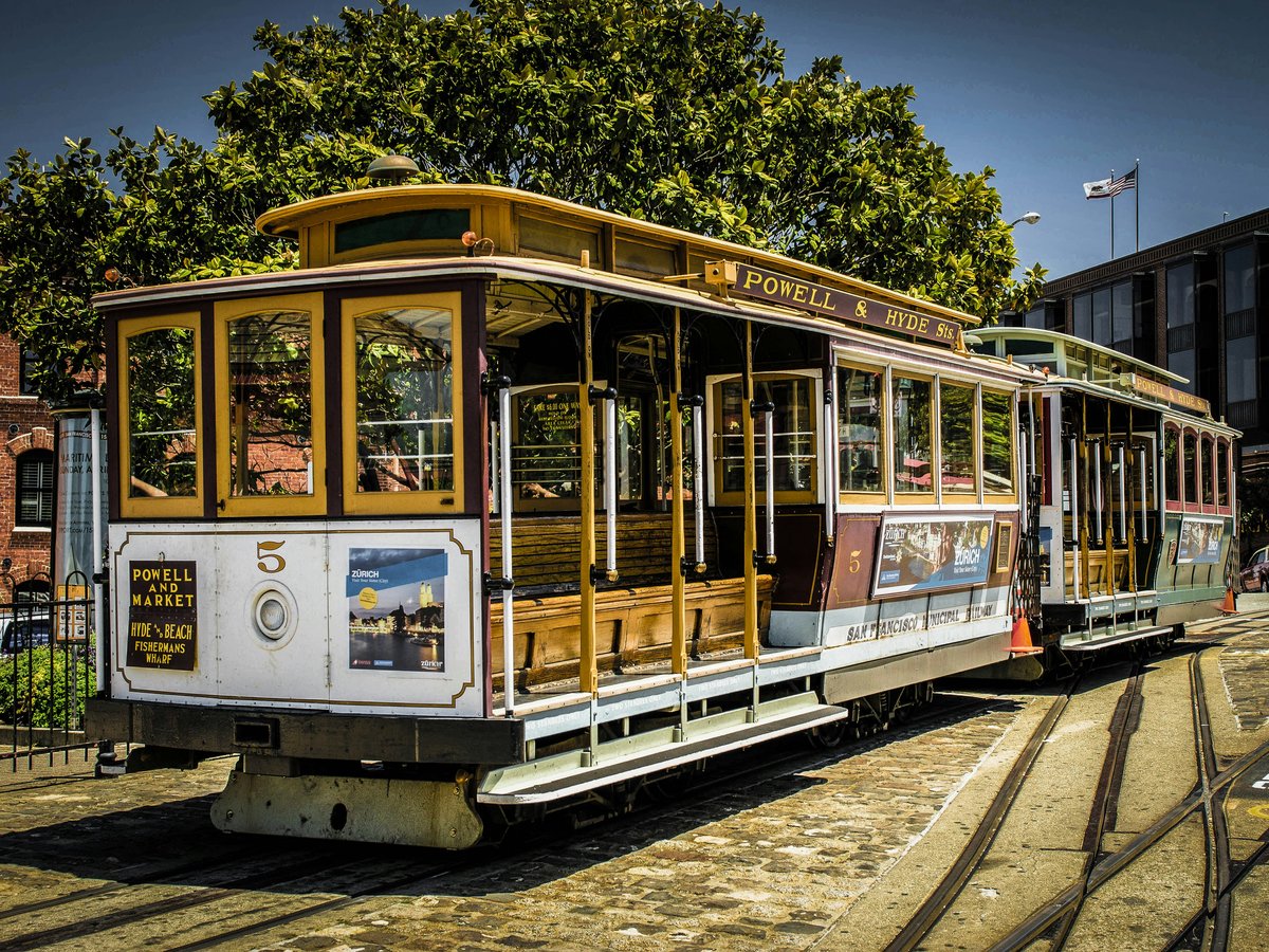 a trolley car sitting on the tracks in a city