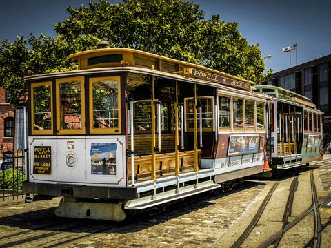 a trolley car sitting on the tracks in a city