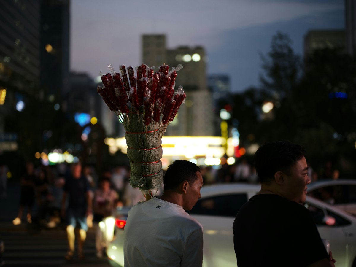 Street vendor with a bundle of items at dusk