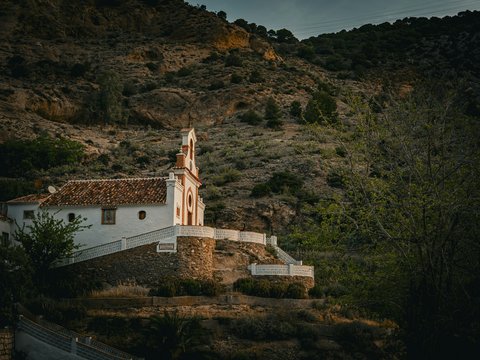 a church on a hill with a steeple in the background