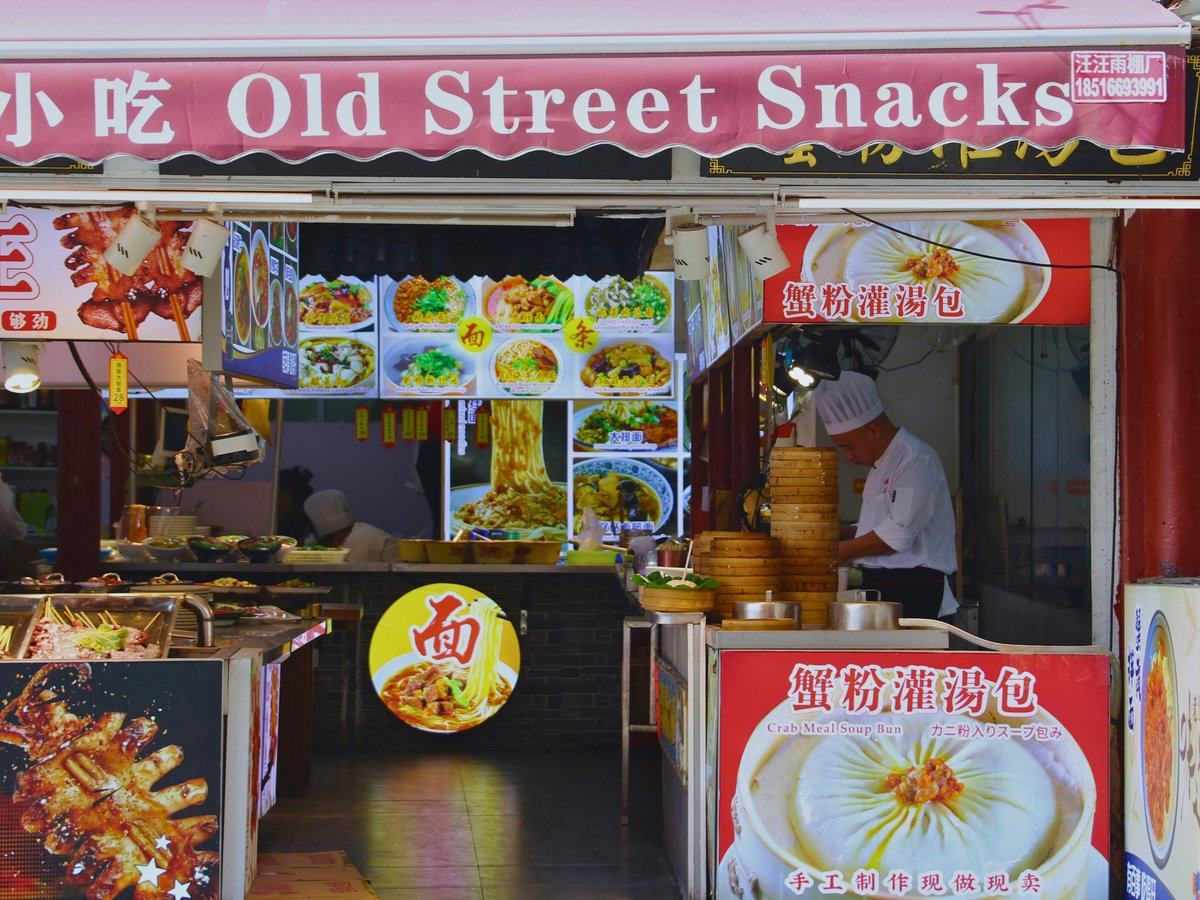 Old street snacks food stall with displayed dishes.