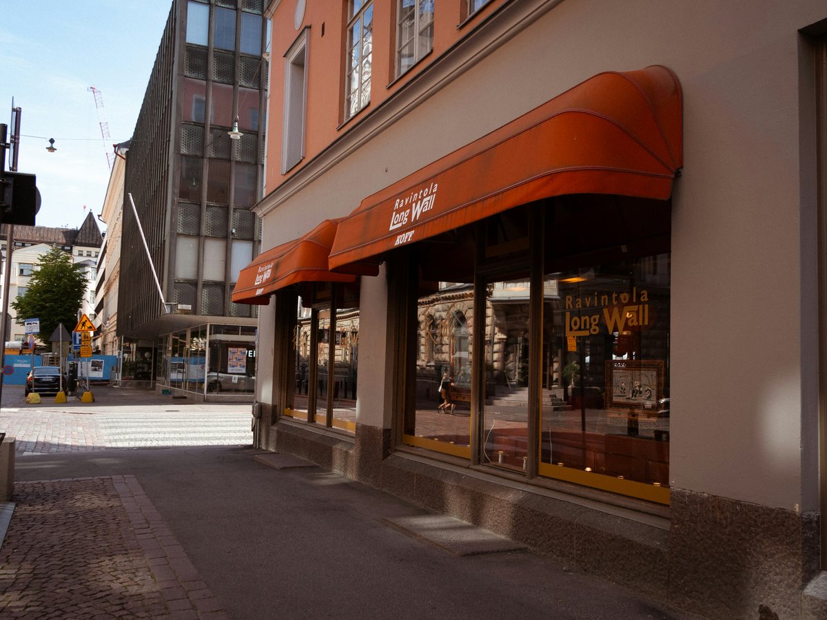 Orange awnings over shop windows on a street.