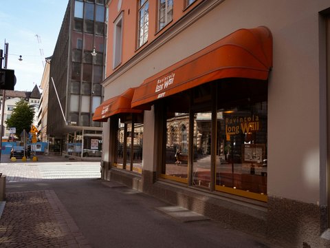Orange awnings over shop windows on a street.