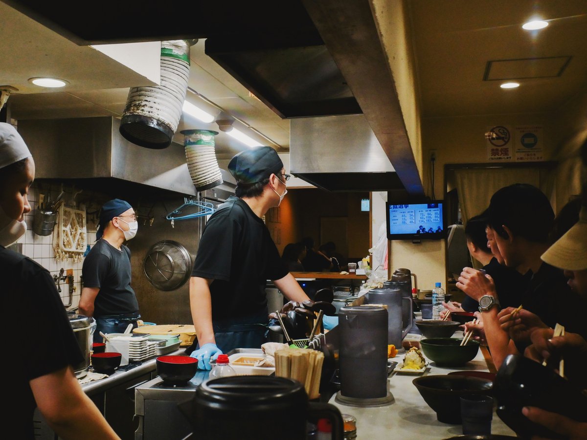 People eating at a busy restaurant counter